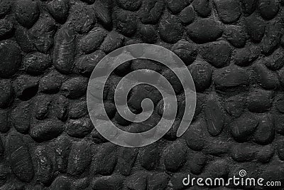 Black stone wall texture of painted natural large pebbles Stock Photo