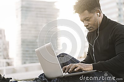 Black student typing in a computer in the city Stock Photo