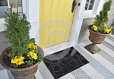 Black Stylish square patterned welcome entry door mat with yellow flowers and leaves Stock Photo