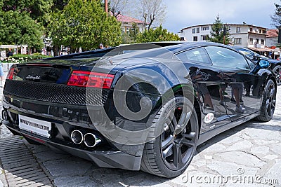 Black supercar Lamborghini with shiny stripes sitting parked in the city Editorial Stock Photo