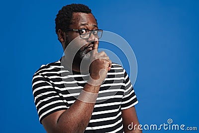 Black surprised man showing silence gesture at camera Stock Photo