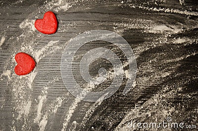 Black table with scattered flour, red dough hearts in the corner, space for text. Top view Stock Photo