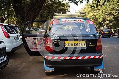 Black taxi on a Mumbai street surrounded by trees and cars Editorial Stock Photo