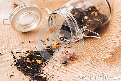 Black tea with natural additives in a glass jar Stock Photo