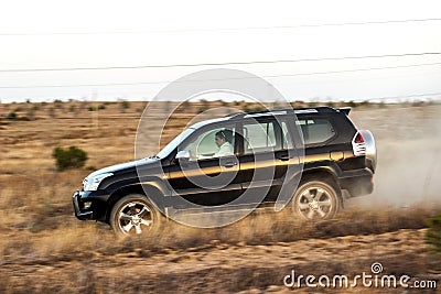 Black Toyota Prado SUV rides in the field in the rays of the sunset Editorial Stock Photo