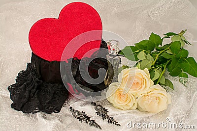 Black underwear knickers in gliter red box heart shaped perfume white roses juwelery on white background Stock Photo