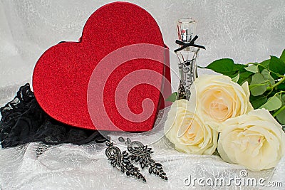 Black underwear knickers in gliter red box heart shaped perfume white roses juwelery on white background Stock Photo