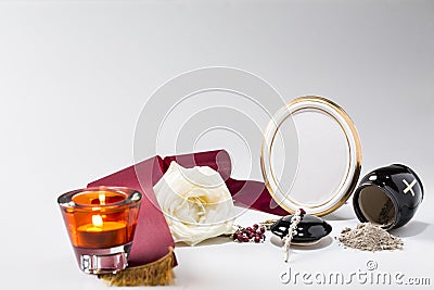 Black urn with red tape,white rose, candle, rosary for sympathy Stock Photo