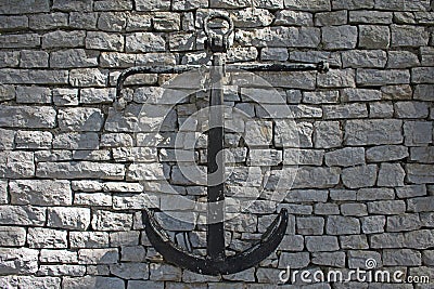 Black vintage anchor hanging on a wall Stock Photo