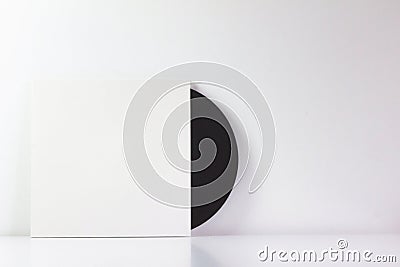 Black vinyl record, in its white box, with blank space to write. With white background. Minimalist photo Stock Photo