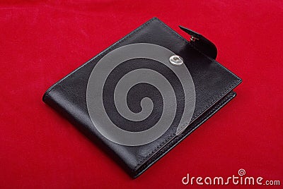 Black leather wallet on red background money purse finance shopping currency object business wealth cash single pay rich personal Stock Photo