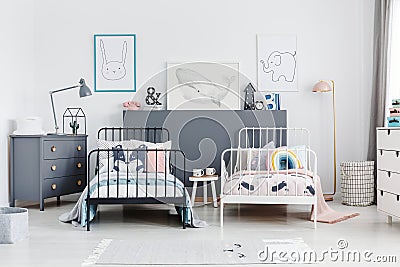 Black and white beds in colorful kids bedroom interior with post Stock Photo