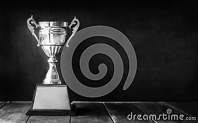 black and white champion trophy on wood table with blackboard co Stock Photo