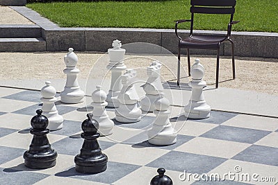 Black and white chessmen on the street chessboard Stock Photo
