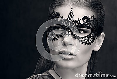 Black and white closeup portrait of a beautiful young woman in black lace mask on the eyes Stock Photo
