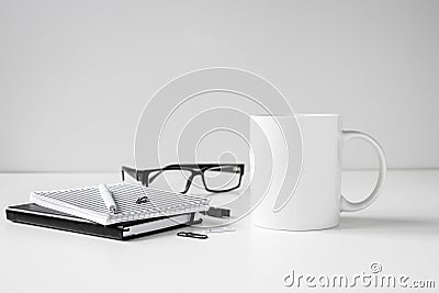 Black and white coffee mug mock up with notebooks, pen and eyeglasses Stock Photo