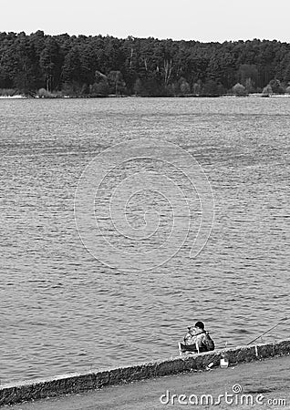 Black & white fisherman on river bank background Stock Photo