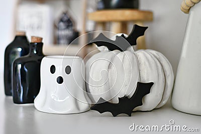 Black and white Halloween decoration with ghost shaped candle, pumpkin, bats and potion bottles Stock Photo