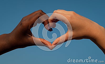 Black and white hands in heart shape, interracial friendship concept Stock Photo