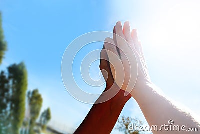 Black and white hands in together in high-five Stock Photo