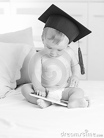 Black and white image baby in graduation hat using tablet Stock Photo