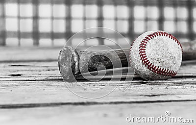 Black and white image of a baseball and bat on wood surface. Stock Photo