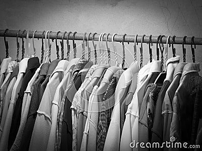 Black and white image of clothes hanging on hanger rack. Choice of fashion clothes on hangers Stock Photo
