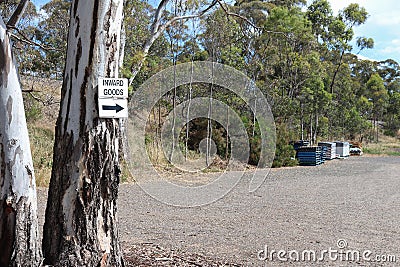 A black and white Inward Goods and arrow signs on a tree Stock Photo