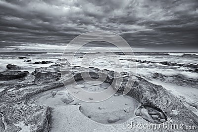 Black and white landscape of ocean rocks and clouds artistic con Stock Photo