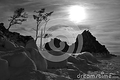 Black and white landscape. The shore of the lake with a rock and trees. Stock Photo