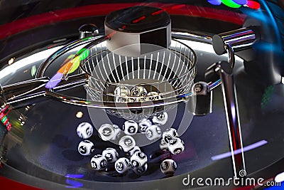 Black and white lottery balls in a rotating bingo machine. Number 16 Stock Photo