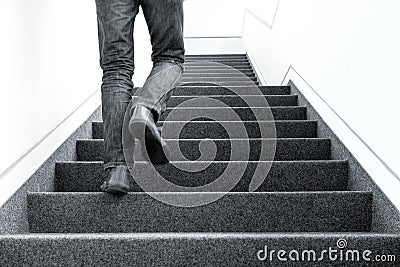 Low angle picture of man walking upstairs on indoors Stock Photo