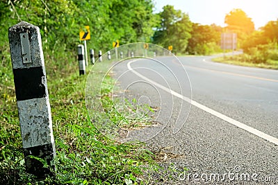 Black and white milestones with green grass roadside, Trees road Stock Photo