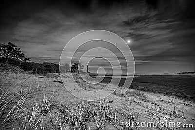 Black and White Moon Rise Over Sand Dunes Stock Photo