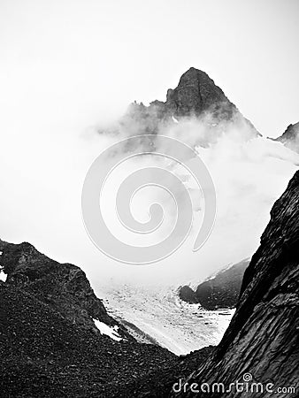 Black and white Mountains in cloud above a glacier Stock Photo