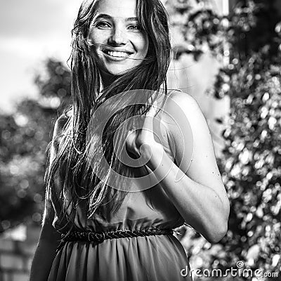 Black-white outdoor portrait of beautiful emotional young brunette woman in stylish dress Stock Photo
