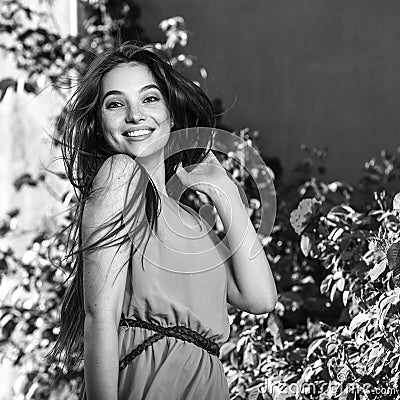 Black-white outdoor portrait of beautiful emotional young brunette woman in stylish dress Stock Photo