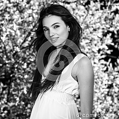 Black-white outdoor portrait of beautiful emotional young brunette woman in stylish dress Stock Photo