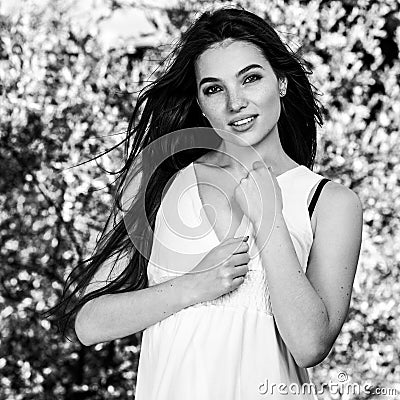 Black-white outdoor portrait of beautiful emotional young brunette woman in stylish dress Stock Photo