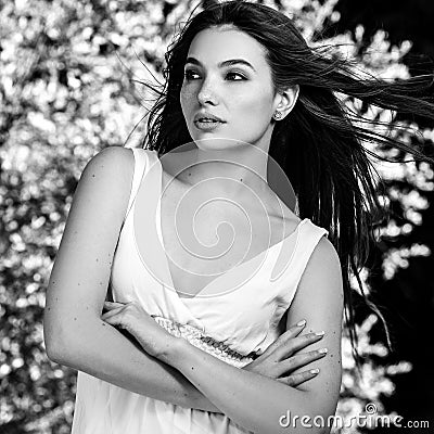 Black-white outdoor portrait of beautiful emotional young brunette woman in stylish dress Stock Photo