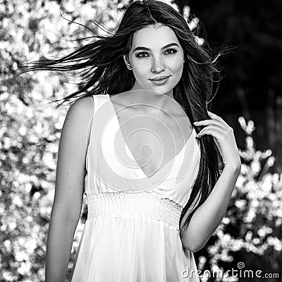 Black-white outdoor portrait of beautiful emotional young brunette woman in stylish dress Stock Photo