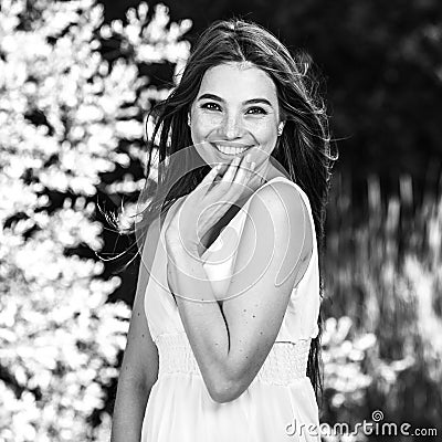 Black-white outdoor portrait of beautiful emotional young brunette woman in stylish dress Stock Photo