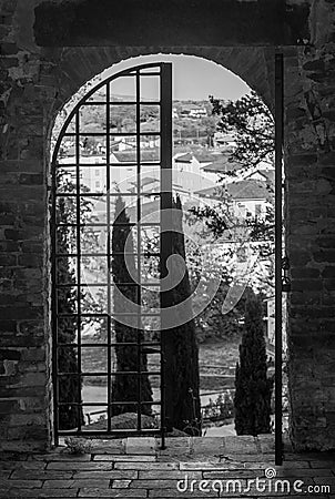Black and white view of the historic center of Fucecchio, Florence, Italy, framed by one of the ancient doors to the Corsini Park Stock Photo