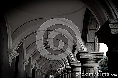 Black and white passage with way forward built from arches and columns and hanging lamps Stock Photo