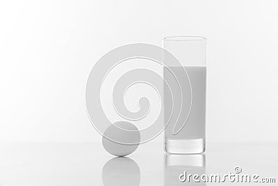 Black and white photo of a glass of pure milk and chicken egg isolated ob white background Stock Photo