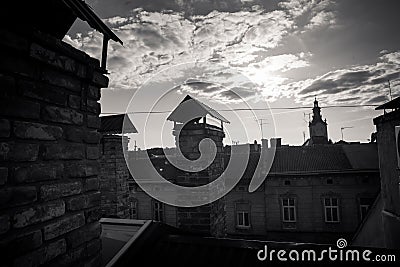 Black and white photo of old historical building rooftop silhouettes against fluffy clouds Stock Photo