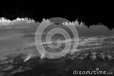 Lake reflecting clouds and tree horizon Stock Photo