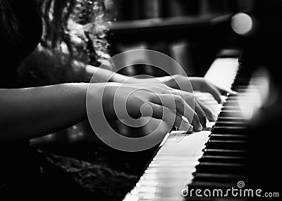 Black and White Photo of Young Lady Playing the Piano Stock Photo