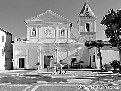 Black and white photography Tortora: square church and baby on bicycle Editorial Stock Photo