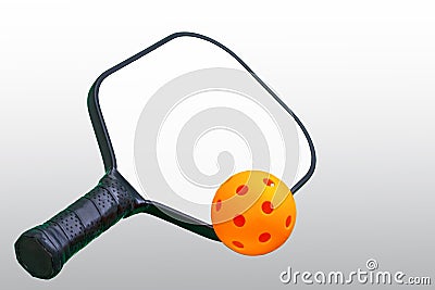 Black and White Pickleball Paddle with Orange ball. Stock Photo